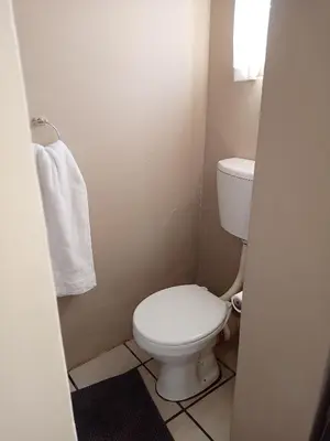 a bathroom with a toilet and a white towel at Accommodation@Park1285 in Pretoria