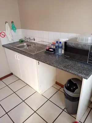 a kitchen counter with a sink and a microwave at Accommodation@Park1285 in Pretoria