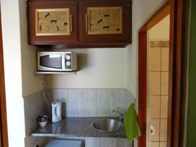 a small kitchen with a sink and a microwave at Lephalale Guest House in Ellisras