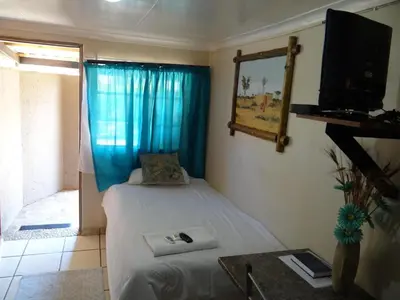 a small room with two beds and a television at Lephalale Guest House in Ellisras