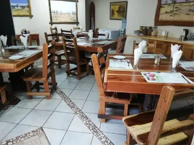 a dining room with wooden tables and chairs at Lephalale Guest House in Ellisras