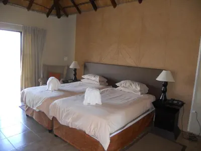 a bedroom with a large bed with white sheets and pillows at BushTime Mabula in Mabula