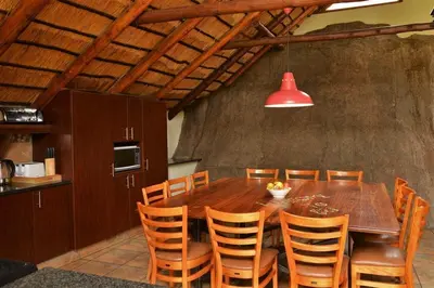 a dining room with a wooden table and chairs at BushTime Mabula in Mabula