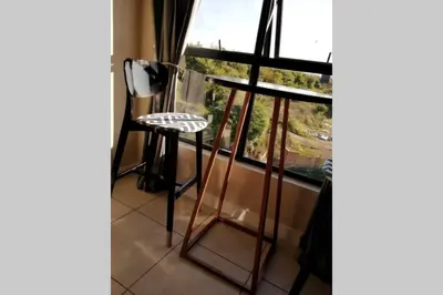 a table and stool in front of a window at The Blyde Modern Oasis Pretoria in Pretoria