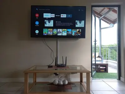 a tv hanging on a wall above a table at The Blyde Modern Oasis Pretoria in Pretoria