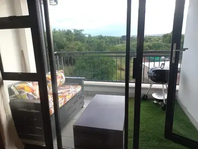 a room with a balcony with a bed and a desk at The Blyde Modern Oasis Pretoria in Pretoria