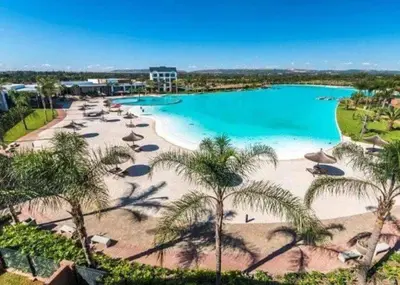 a beach with umbrellas and a pool of water at The Blyde Modern Oasis Pretoria in Pretoria