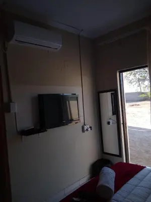 a bedroom with a bed and a tv on the wall at Rayon guesthouse in Phalaborwa