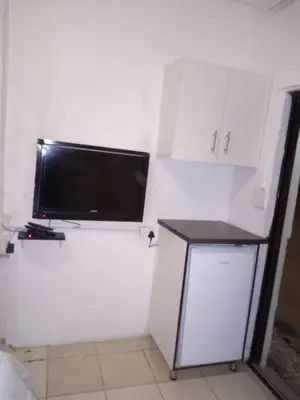 a flat screen tv sitting on a white wall at Rayon guesthouse in Phalaborwa