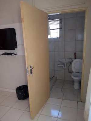 a bathroom with a toilet and a television in it at Rayon guesthouse in Phalaborwa