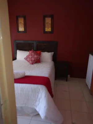 a bedroom with two beds with red walls at Rayon guesthouse in Phalaborwa