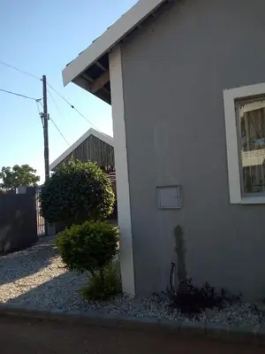 a white house with a window and a bush at Rayon guesthouse in Phalaborwa