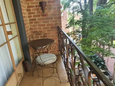 a balcony with a table and chairs on a porch at Claires of Centurion in Centurion