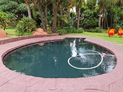 a pool of water with a hose in a yard at Casa De Jardim Guesthouse in Centurion