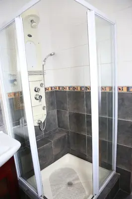 a shower with a glass door in a bathroom at Casa De Jardim Guesthouse in Centurion