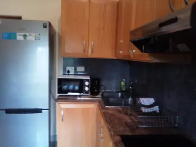 a kitchen with a refrigerator and a sink and a microwave at Aloha Lodge 2 Bedroom Apartment near Menlyn Sleeps 4 in Pretoria