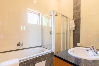 a bathroom with a sink and a shower and a tub at Aloha Lodge 2 Bedroom Apartment near Menlyn Sleeps 4 in Pretoria
