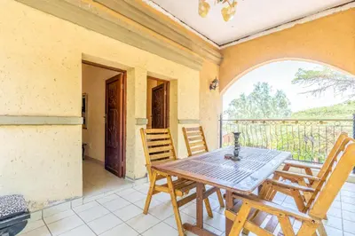 a dining room with a table and chairs on a balcony at Aloha Lodge 2 Bedroom Apartment near Menlyn Sleeps 4 in Pretoria