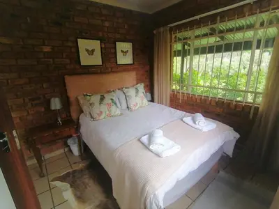 a bedroom with a bed with towels on it at Stone Circle Cottage in Lydenburg