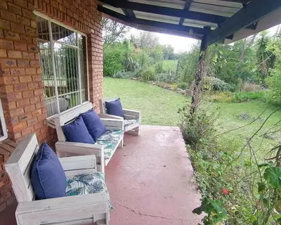 a porch with couches on a brick building at Stone Circle Cottage in Lydenburg