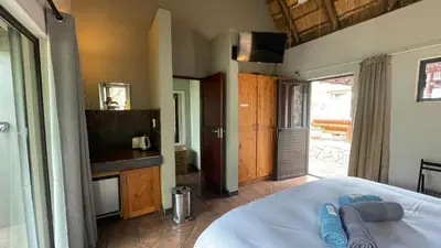 a bedroom with a bed and a tv in a room at Ujabule Lodge in Hoedspruit