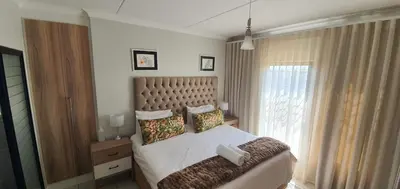 a bedroom with a large bed and a window at Lush Living The Blyde Riverwalk Estate Unit 101 in Pretoria