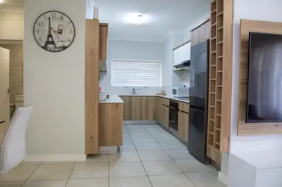 a kitchen with a large clock on the wall at Lush Living The Blyde Riverwalk Estate Unit 101 in Pretoria