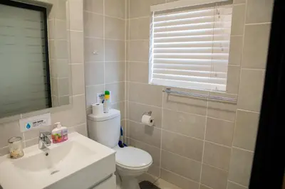 a bathroom with a white toilet and a sink at Lush Living The Blyde Riverwalk Estate Unit 101 in Pretoria