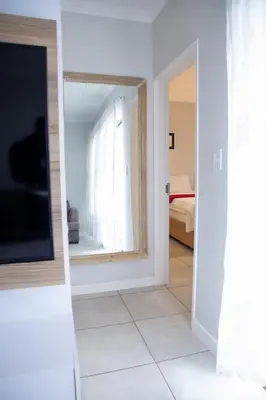 a hallway with a mirror and a room with a bedroom at Lush Living The Blyde Riverwalk Estate Unit 101 in Pretoria