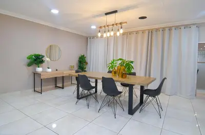 a dining room with a wooden table and chairs at Upmarket Villa with pool & lush garden in Pretoria