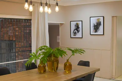 a dining room with two vases on a table with plants at Upmarket Villa with pool & lush garden in Pretoria