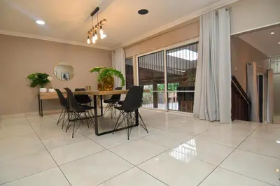 a dining room with a table and chairs at Upmarket Villa with pool & lush garden in Pretoria