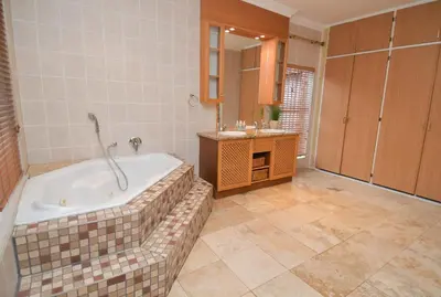 a bathroom with a bath tub and a sink at Upmarket Villa with pool & lush garden in Pretoria