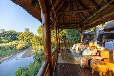 an outdoor living room with a couch and a river at Karongwe - River Safari Lodge in Hoedspruit