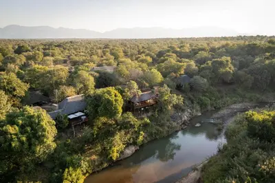 an aerial view of a train crossing a river at Karongwe - River Safari Lodge in Hoedspruit