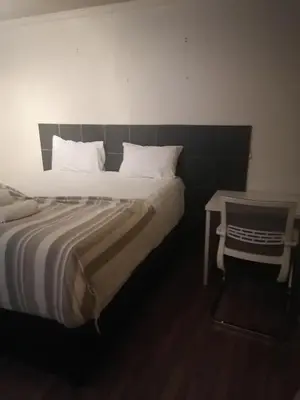 a bedroom with a large bed and a table at 180 On Anderson Guest House in Pretoria
