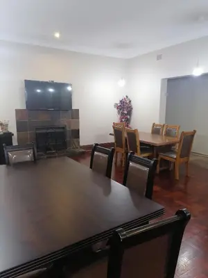 a room with a table and chairs and a fireplace at 180 On Anderson Guest House in Pretoria