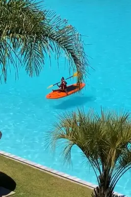a man on a kayak in the water next to a palm tree at The Blyde 104 in Pretoria