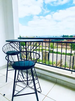 a table and a chair on a balcony with a view at The Blyde 104 in Pretoria
