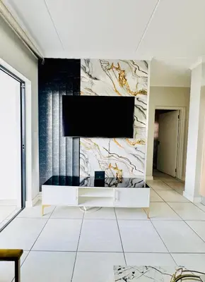 a living room with a flat screen tv on a wall at The Blyde 104 in Pretoria