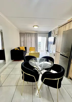 a living room with a glass table and chairs at The Blyde 104 in Pretoria