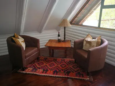 a living room with two chairs and a table at Kruger River Villas- Treetop Loft in Marloth Park