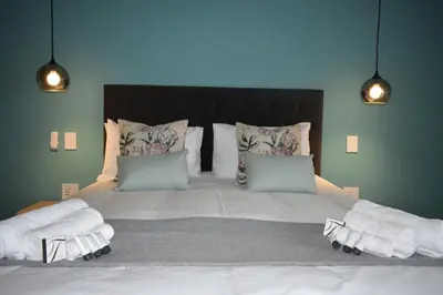 a bedroom with a large bed with towels on it at Mosswood Bed & Breakfast in Graskop