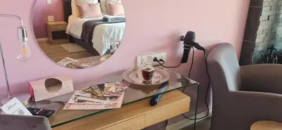 a room with a mirror and a glass table with a lamp at Mosswood Bed & Breakfast in Graskop