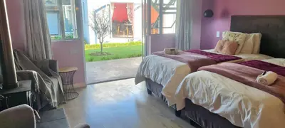 a bedroom with two beds and a large window at Mosswood Bed & Breakfast in Graskop
