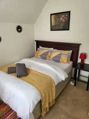 a bedroom with two beds and a table with a lamp at Rural feeling Self Catering Next door to Sandton in Midrand