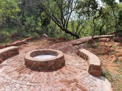 a brick patio with a fire pit in the middle at Rock Cottage, Bela-Bela in Bela-Bela