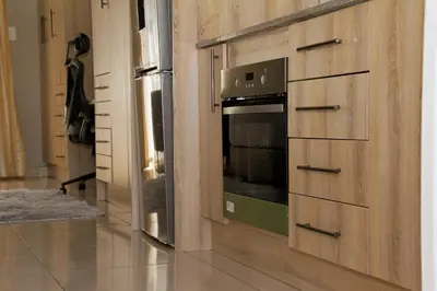 a kitchen with a stove and a refrigerator at Beautiful Studio Cottage at Menlyn Maine in Pretoria