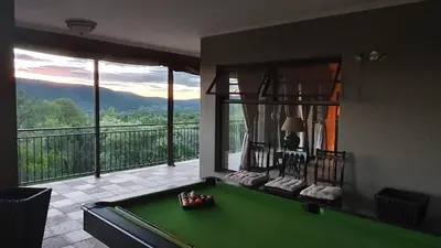 a room with a pool table in front of a balcony at Zwartkloof View, Bela Bela in Bela-Bela
