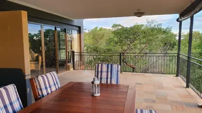 a patio with a wooden table and chairs on a balcony at Zwartkloof View, Bela Bela in Bela-Bela
